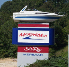 A Marine Max sign made by mid state signs with a large boat replica attached to the top of the sign